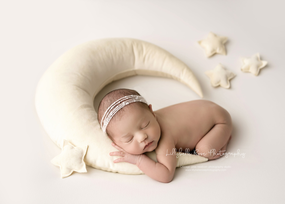 posed newborn with moon prop