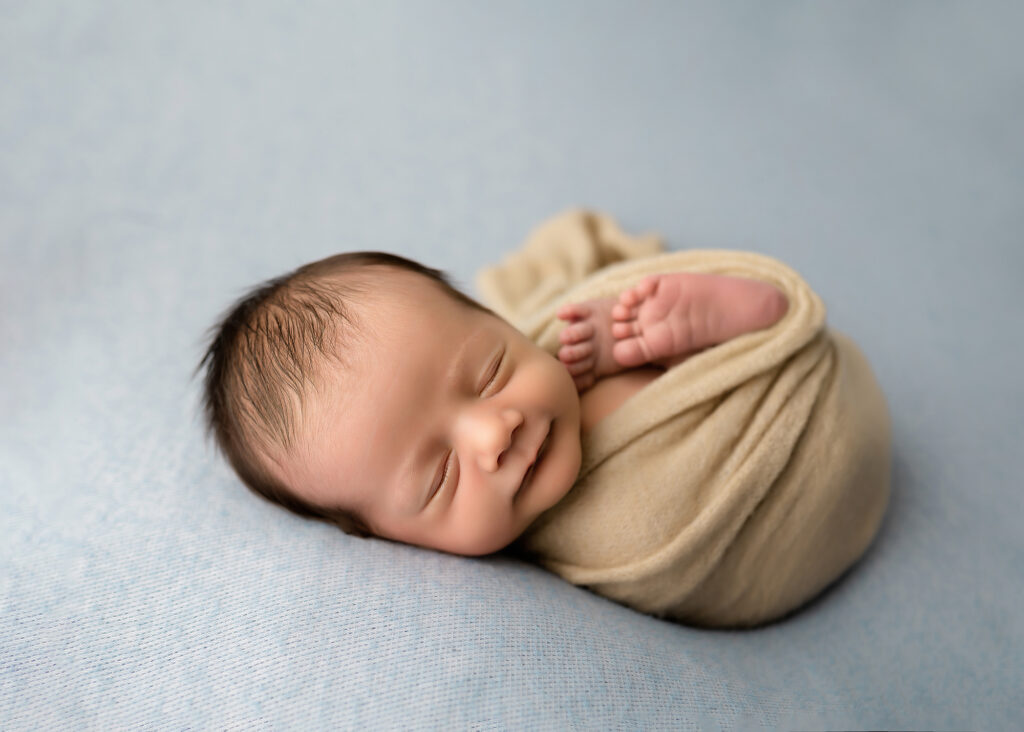 prenatal-genetic-testing, baby smiles while swaddled
