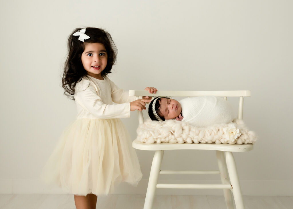 Big sister with baby in newborn studio session