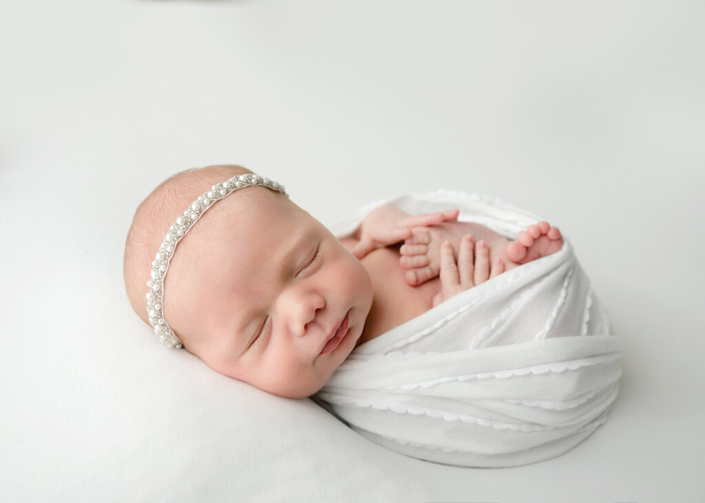 baby wearing sparkly headband of pearls and crystals