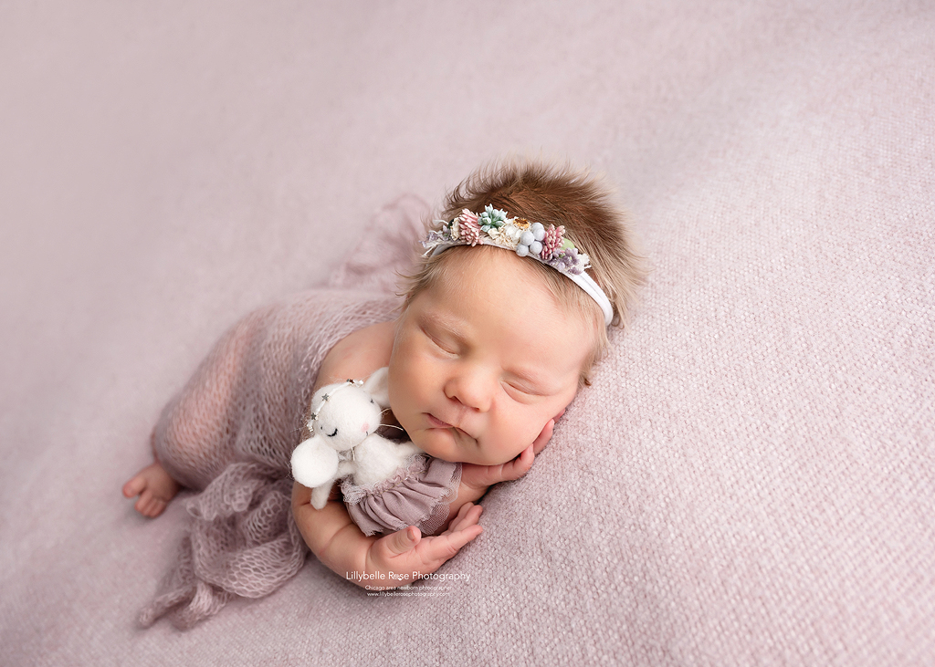 Adorable baby girl with ballerina doll and cute floral headband